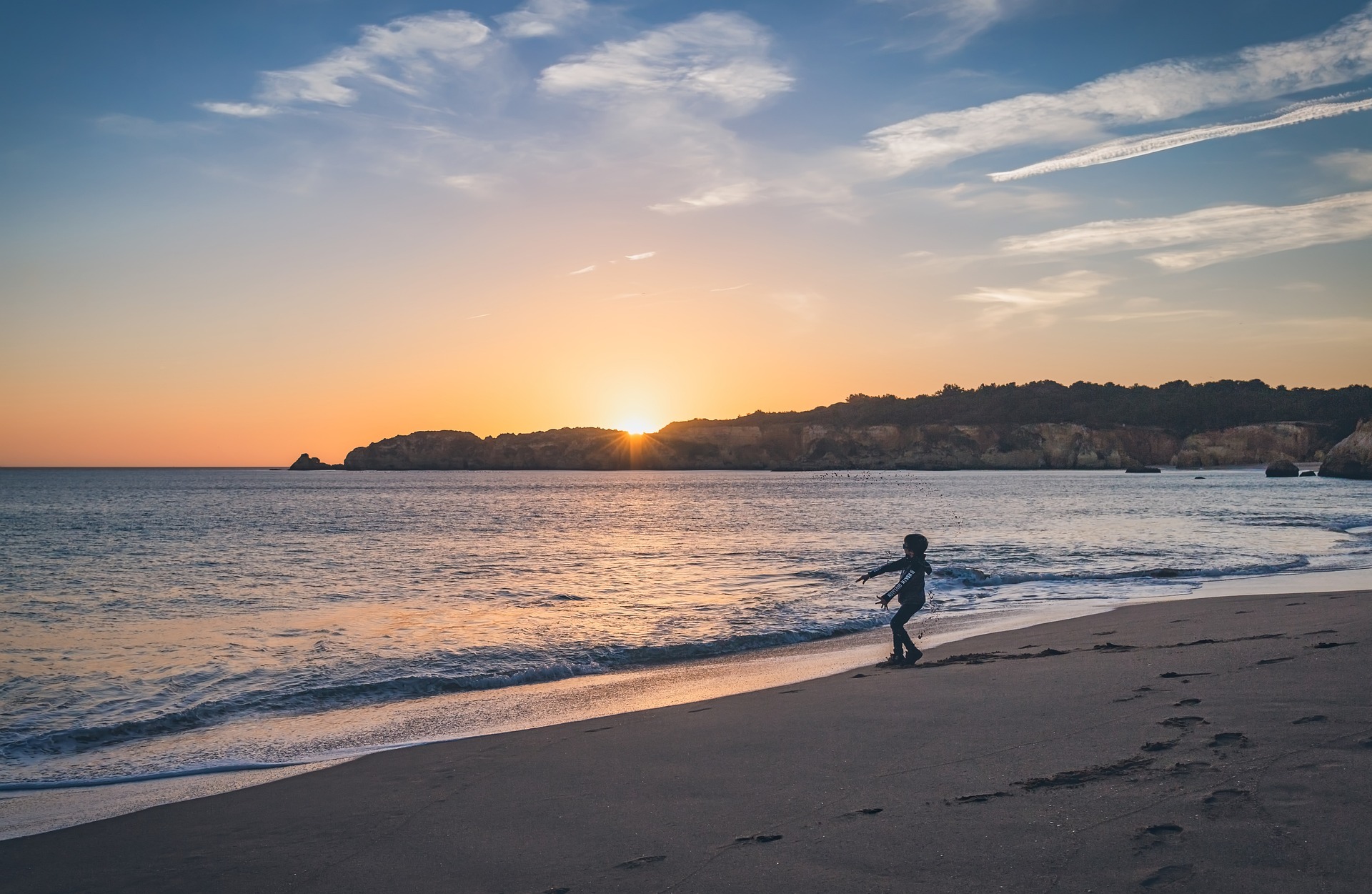 A boy enjoying the beach at sunset in Bude